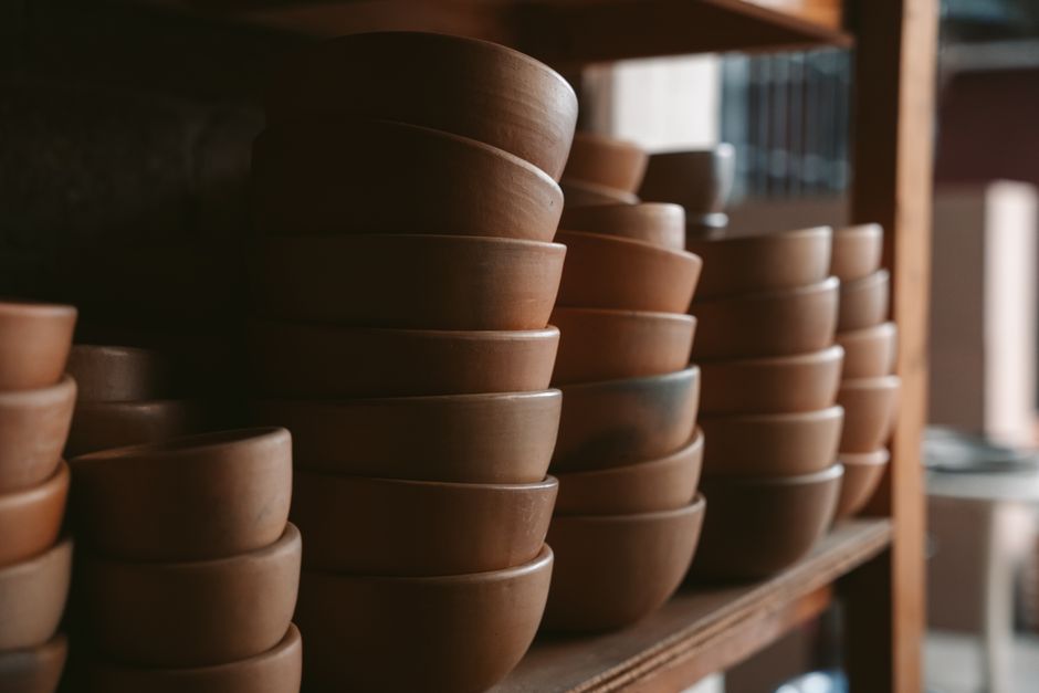 Rustic clay bowls stacked in a traditional Oaxaca workshop, showcasing Mexican craftsmanship.